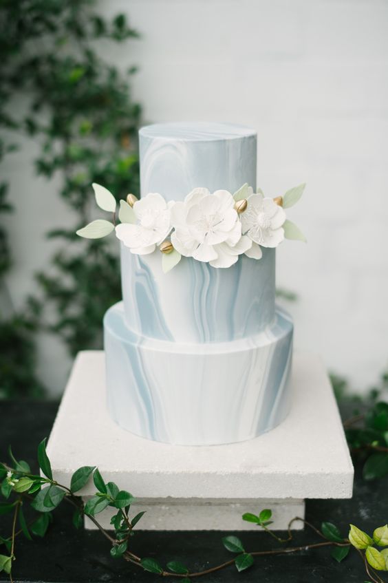wedding cake with ivory sugar flowers with green leaf accent for blue green and white spring wedding 2021