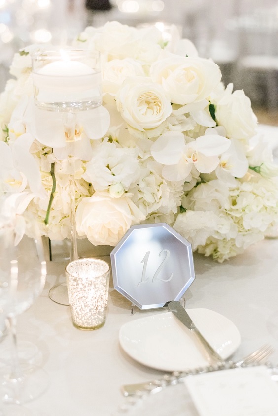 silver table number and ivory flower centerpiece for silver and white spring wedding 2021