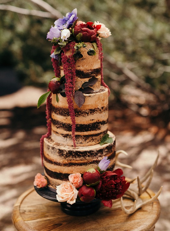 black naked wedding cake with burgundy flowers for black and burgundy fall wedding 2020