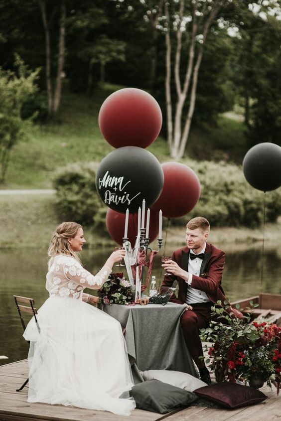 reception table with florals and balloons for black and burgundy fall wedding 2020
