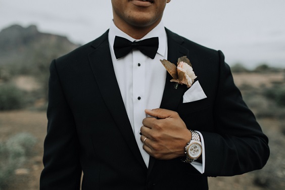 black mens suit with beige boutonniere for white beige and sage green fall wedding 2020