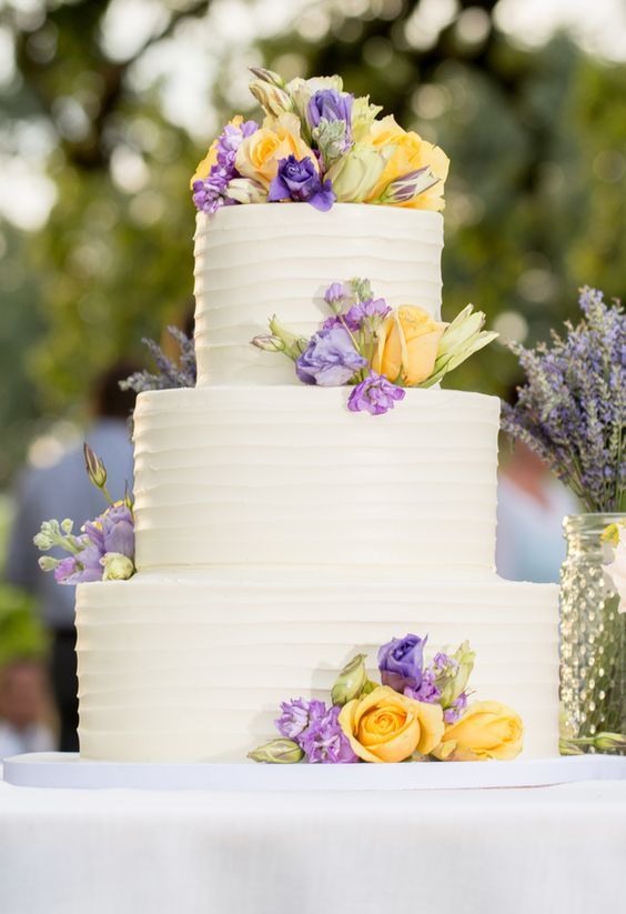 white cake with lavender yellow flower decoration for lavender and yellow august wedding color 2020