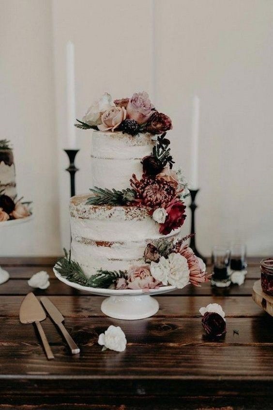 wedding cake dotted with flowers and greenery for sage green and burgundy december wedding 2020