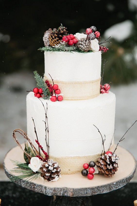 white wedding cake dotted with red berries for dark red and white december wedding 2020