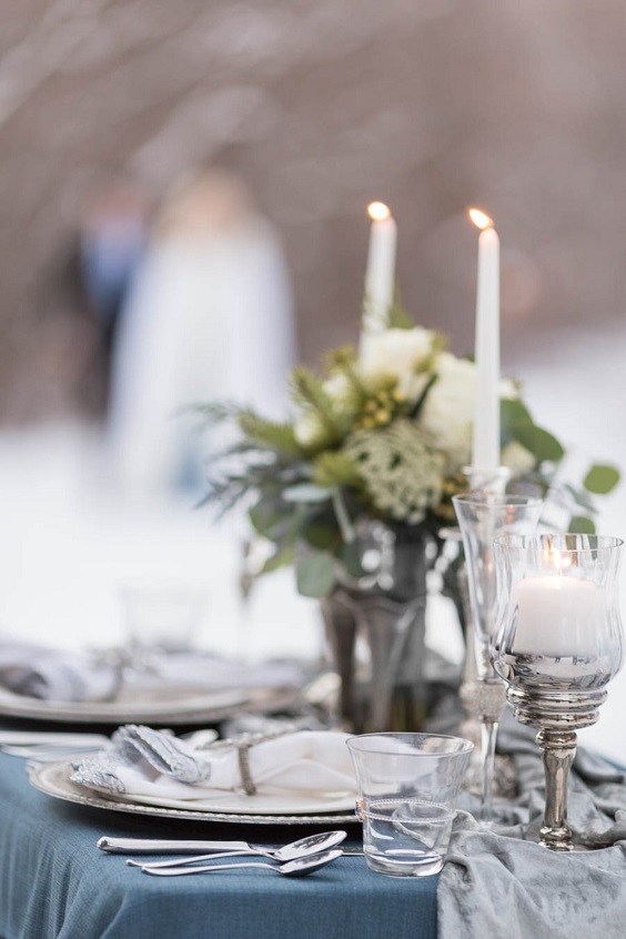 table setting and centerpiece for dusty blue and silver december wedding 2020