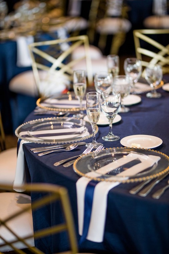navy blue tablecloth and gilded plates for navy blue and gold december wedding 2020