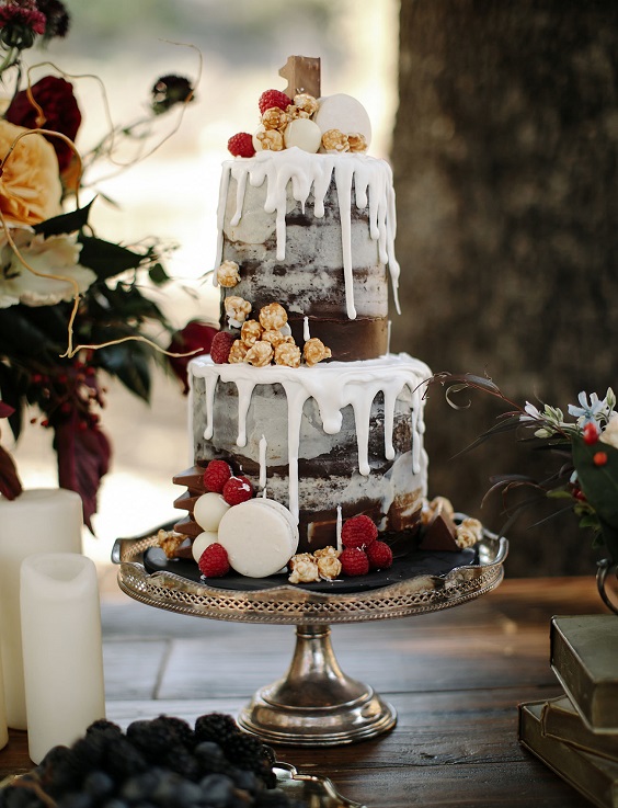 white and grey drip wedding cake with berries and popcorn for burgundy fall wedding colors burgundy and grey