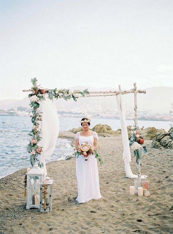 white ceremony arch with flowers for white boho beach wedding