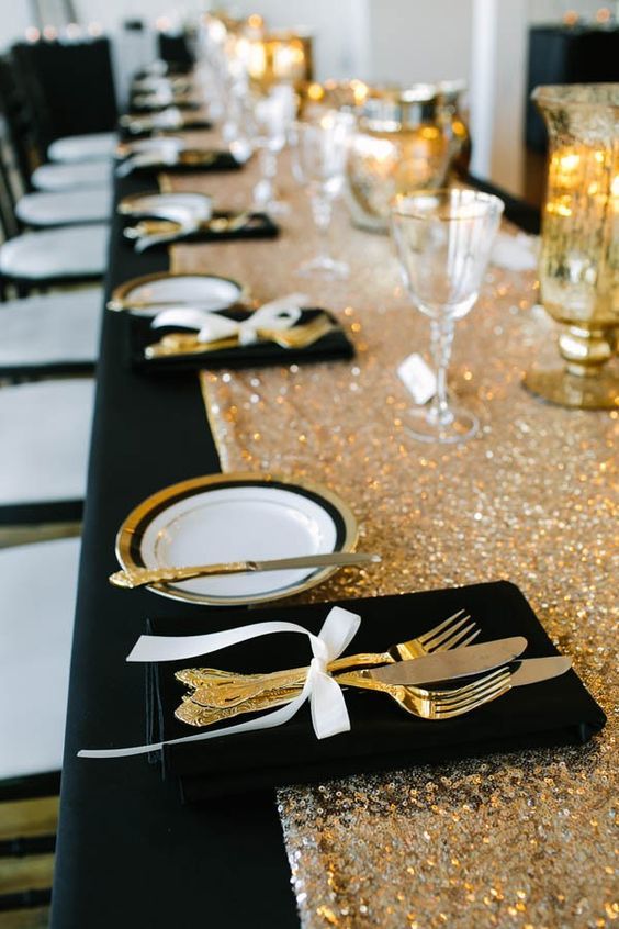 black and gold tablescape with black napkin gold knife and fork for black wihte gold wedding color
