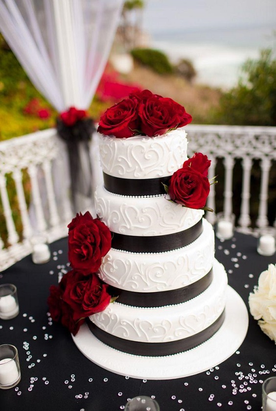 white wedding cake with red flowers and black sash for red and black wedding colors red black and white