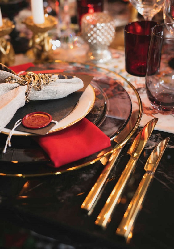 black tablecloth gilded knives and red napkin for red and black wedding colors red black and gold