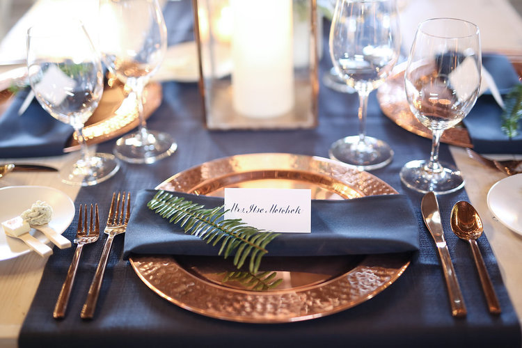navy blue tablecloth and rust charger and cutlery for navy gold and rust wedding color combo
