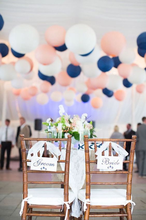 navy blue and blush balloons and golden chairs for navy gold and blush wedding color combo