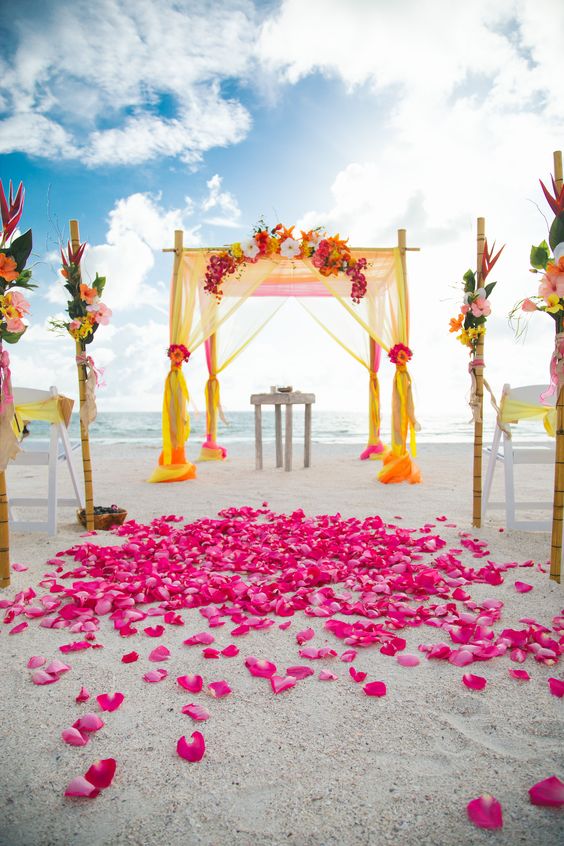 pink wedding flowers decorations and yellow ceremony arch for pink and yellow simple beach wedding