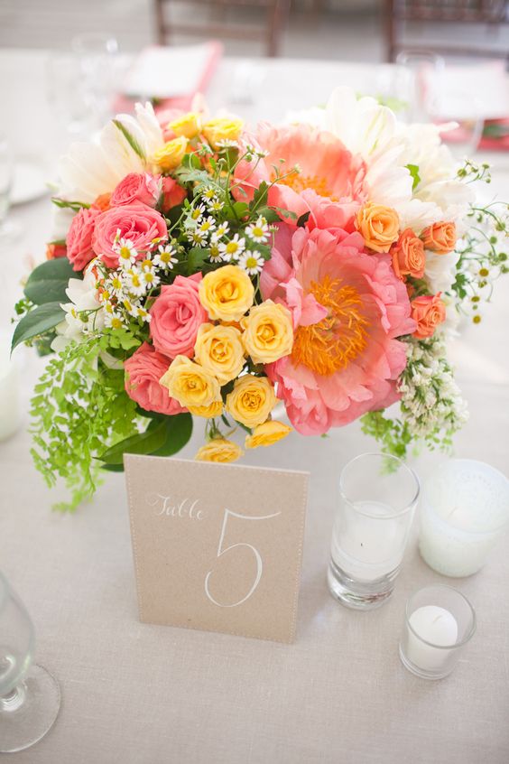 wedding table number with pink and yellow flower decorations for pink and yellow simple beach wedding