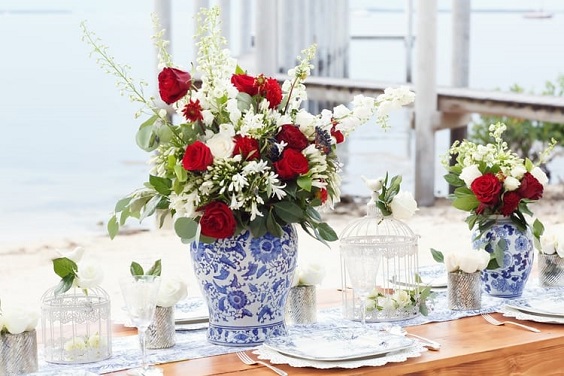 blue mason jar centerpieces with red flowers for red and blue simple beach wedding