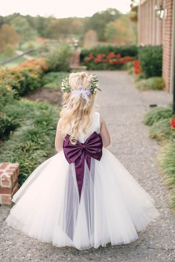 white flower girl dress with plum bow for rustic outdoor wedding colors plum lilac and green