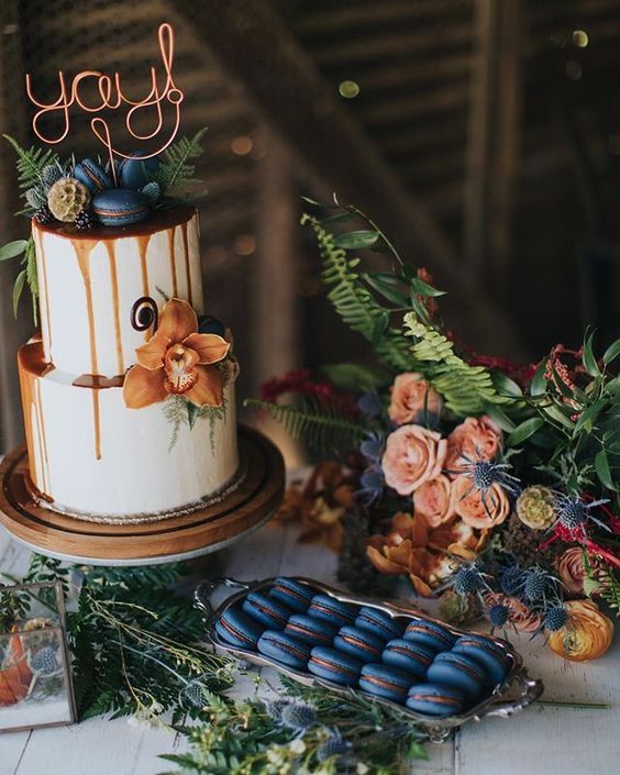 white wedding cake dotted with copper flower and navy macaroons for white barn wedding colors navy white and copper
