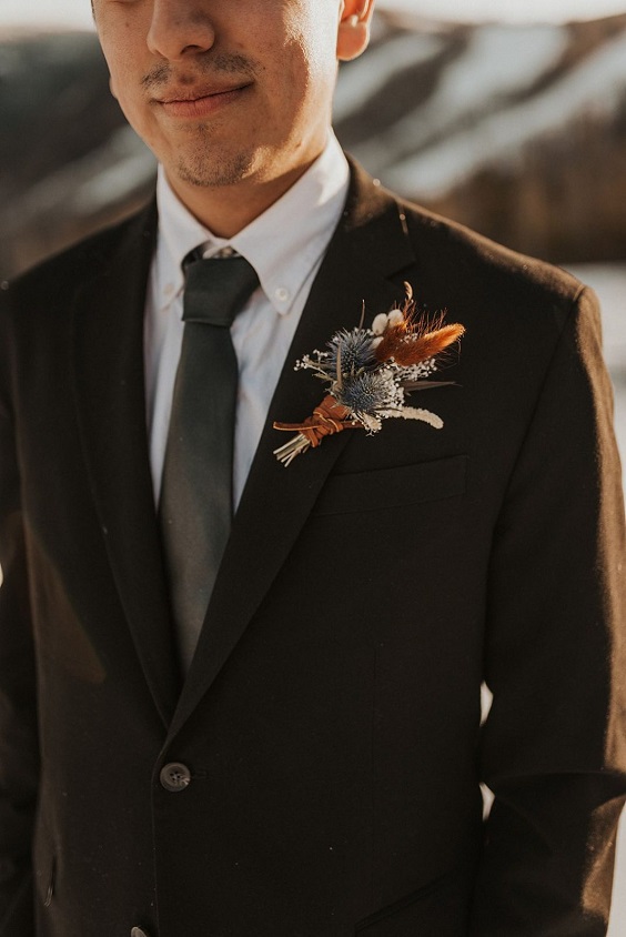 black grooms attire and boutonniere for black outdoor winter wedding
