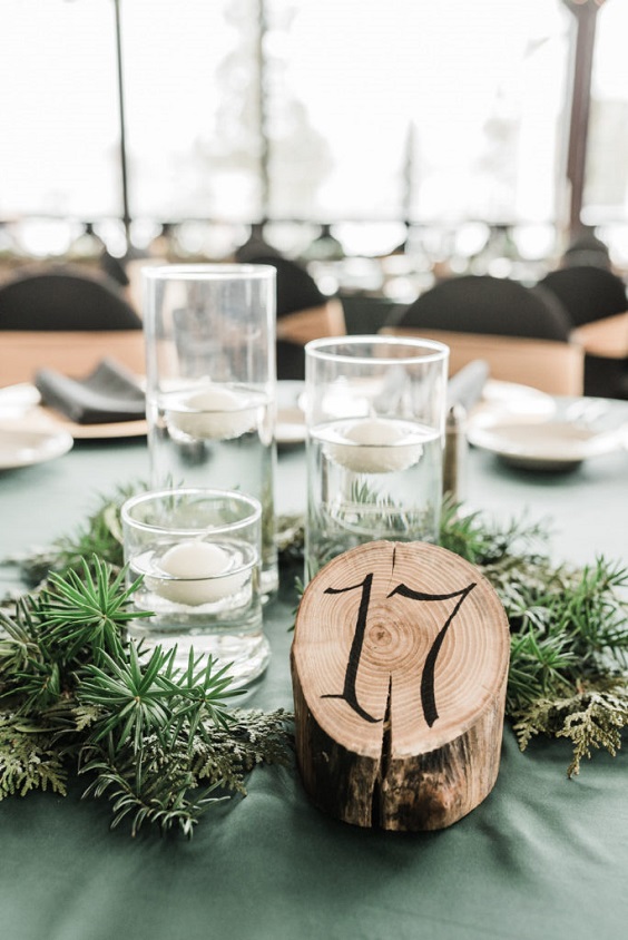 emerald green wedding tablecloth and black wedding table number with greenery for winter wonderland wedding color emerald green and black