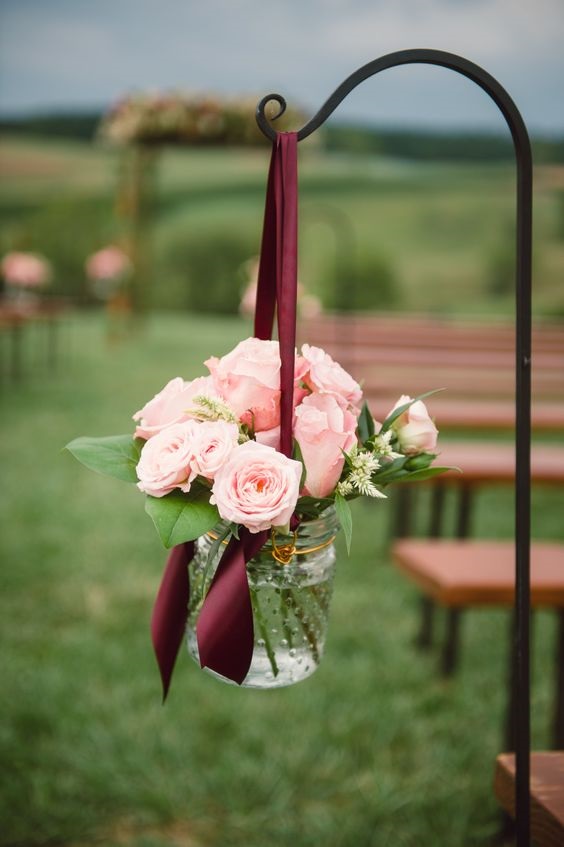 mason jar centerpieces with pink flowers and burgundy ribbon for pink burgundy rose gold and burgundy wedding