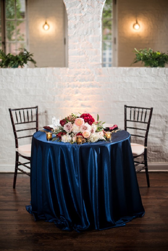navy blue sweatheart table with burgundy flower and greenery decoration for burgundy and navy wedding color winter